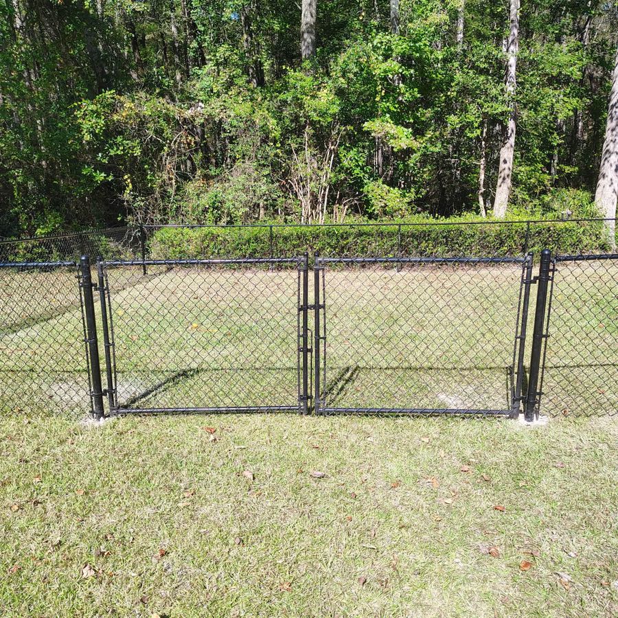 Black vinyl coated chain link fence with a walk gate