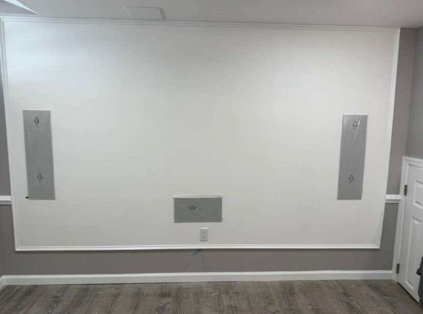 Finished screen wall with in-wall speaker locations and trim