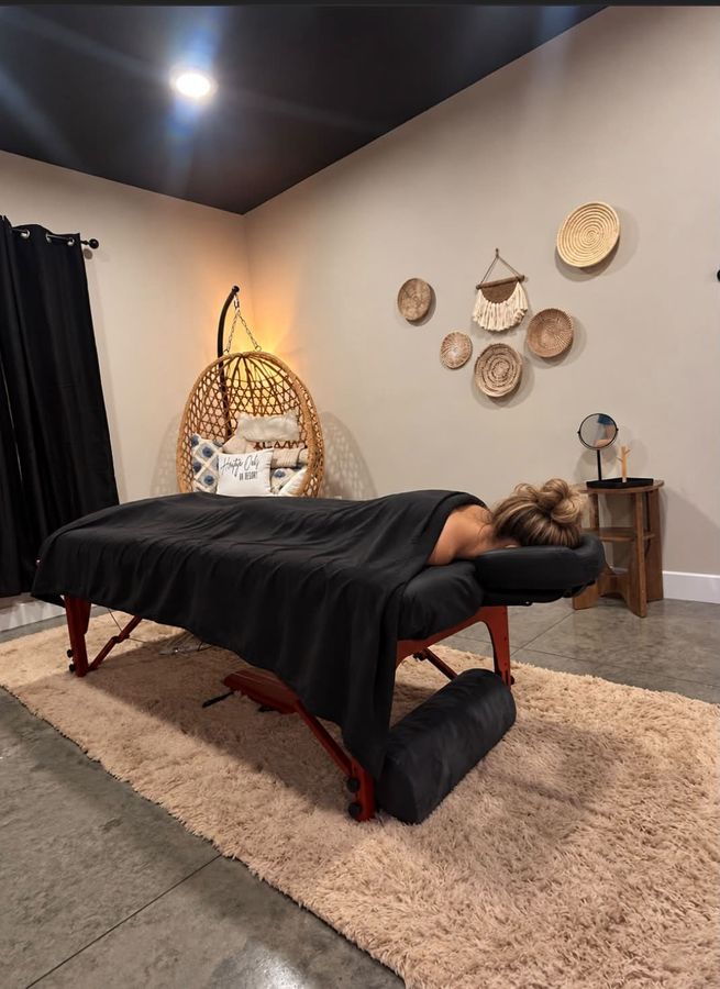 The Heritage Relaxation Room with a massage table, hanging chair and soft lighting