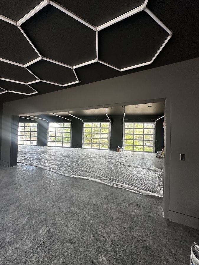 Large garage with a hexagon light ceiling and a freshly coated epoxy floor